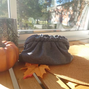 Clutchbag i jeans - Nu har vi släppt en av våra annorlunda designs. Denna väska har en scrunchie liknande del vid väskramen som gör denna unik!🩵