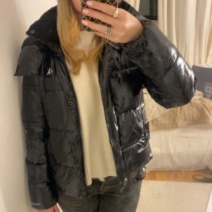 Svart pufferjacka från Calvin Klein - Säljer en svart, glansig pufferjacka från Calvin Klein med dragkedja och tryckknappar utan några defekter🥰