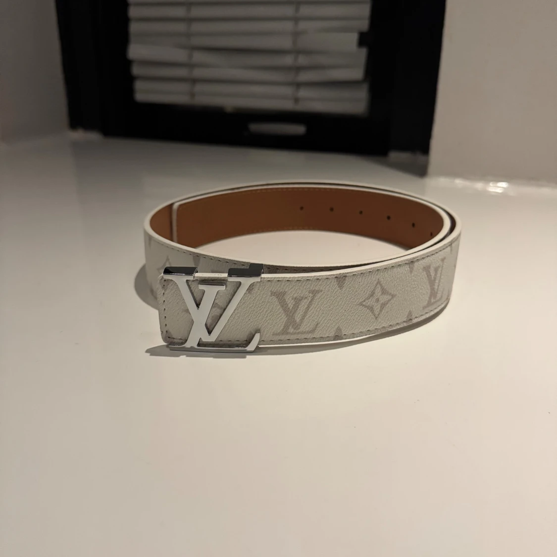 Vitt bälte med mönster och silverfärgat spänne