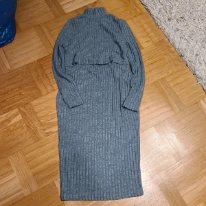 Grå ribbad långklänning från SHEIN - Mysig grå långklänning från SHEIN i storlek S. Klänningen är ribbstickad med lång ärm och hög krage, perfekt för kyligare dagar. Den har en figurnära passform och är tillverkad i ett mjukt, stretchigt material som känns skönt mot huden. Funkar bra vid amning.