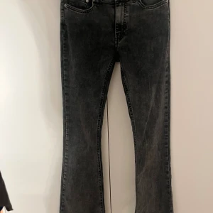 Svarta bootcut jeans med rå kant - Snygga svarta jeans med bootcut-modell och rå, fransad kant nertill. Jeansen har klassisk femficksdesign och en tvättad svart färg som ger en cool vibe. Perfekta för dig som gillar en avslappnad men trendig stil. Dom är i Mid Waist men går att ha som low waist! Köpta för 400kr. Pris kan diskuteras🫰