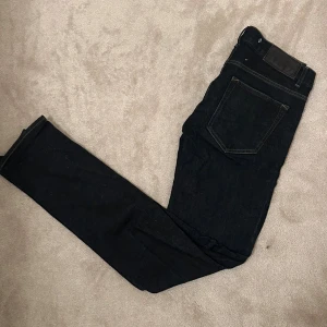  tiger of Sweden jeans - Säljer ett par svarta jeans med klassisk femficksdesign och raka ben. Jeansen är tillverkade i ett slitstarkt denimtyg och har en snygg mörk tvätt. Perfekta för dig som gillar en tidlös och clean look.