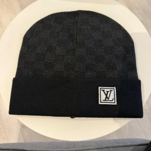 Svart rutig mössa med vit logga - Säljer en riktig snygg svart rutig mössa för ett rimligt pris. Helt oanvänd och perfekt för dig som vill ha en bekväm men också snygg mössa inför vintern. Topp kvalité, prisvärt och postar inom kort. Frågar? Dma😁