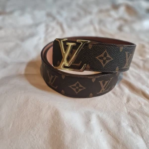 Bälte brunt med guld spänne 110 cm - LV bälte med guld spänne 110 cm i väldigt bra skick.