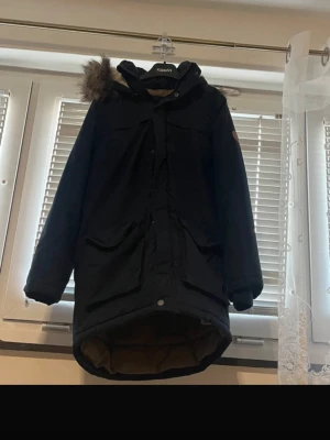 Name It Kids Winter Parka Jacket – Size 12Y (152) – Warm & Hooded - Warm and stylish winter parka from Name It for kids. Perfect for cold weather with a padded design and a cozy hood with faux fur trim. Details: Brand: Name It Type: Winter parka / padded jacket Size: 12 years (152 cm) Color: Dark navy / black Hood: Yes (with faux fur trim) Closure: Zip and snap buttons Season: Autumn / Winter Gently used and well taken care of. Clean and ready to wear. Ideal for school, everyday wear, and winter activities. Feel free to message me if you have any questions 😊 