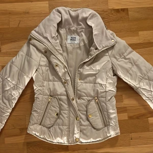 Biege vår jacka från Vero Moda - Fantastiskt vacker NY vitkrämig jacka från Vero Moda. Jackan fleece i nacken med både dragkedja och knappar. Den har praktiska fickor med dragkedja och guldfärgade detaljer. Perfekt för våren🌸☀️storlek XS men passar även 160cm. Hör bara av er om frågor eller annat 
