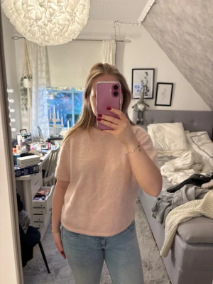 Ljusrosa stickad kortärmad tröja - Supermjuk och fluffig ljusrosa stickad tröja med korta ärmar och rund hals. Perfekt att styla med jeans eller kjol för en chill look. Tröjan har en enkel design utan mönster och är riktigt skön att ha på sig. Storlek 170 men passar xs/s