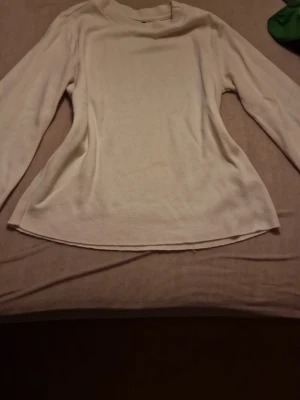 Vit långärmad tröja Gina Tricot XS - En enkel och stilren vit långärmad tröja från Gina Tricot i storlek XS. Tröjan har rund halsringning och är gjord i ett mjukt, stickat material som passar perfekt till lager på lager under höst och vinter. Priset kan diskuteras🫶