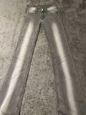 Grå bootcut jeans från Cheap Monday - Snygga grå jeans från Cheap Monday med bootcut-snitt och klassisk femficksdesign. Jeansen har en ljus tvätt längs bene. Tillverkade i jeansmaterial med normal passform och lowwaist. Säljer pga för korta