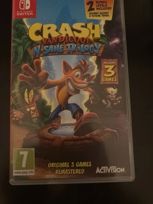 Crash Bandicoot N. Sane Trilogy (Nintendo Switch) - Crash Bandicoot N. Sane Trilogy till Nintendo Switch. Innehåller tre klassiska spel, remastrade med förbättrad grafik och animationer. Fodral och spelkort i fint skick, inga synliga skador. Perfekt för plattformsspelälskare!