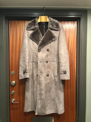 Varm vintage shearling, fint skick  - Äkta shearling-rock från gissningsvis 70/80-tal, otroligt mjuk päls och mocka i toner av grått. Skulle passa bäst på någon som är strl48 (eller mindre ifall man vill ha en lösare passform)