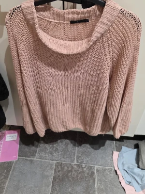 Beige stickad tröja i akryl, M - Säljer en beige stickad tröja från Å i storlek M (40/42). Tröjan har en bred rund halsringning och är gjord i 100% akryl. Den har långärmade och loose passform, perfekt för lager-på-lager under hösten och vintern. Snyggt grovstickad struktur som ger en chill vibe.