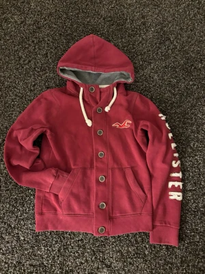 Hollister cardigan - Säljer nu denna väldigt eftertraktade hollister cardiganen. Skick 8/10, sjukt snygg och unik. Denna blir såld fort så skynda! Obs går ner i pris vid snabb affär! 