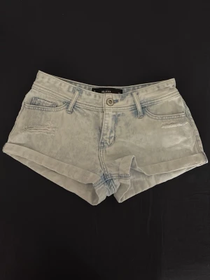 Ljusblå jeansshorts från Hollister - Säljer ett par ljusblå denimshorts från Hollister, modell short-short med låg midja. Klassisk femficksdesign, slitna detaljer framtill och uppvikta benslut. Supersnygga, säljer bara eftersom de har blivit för små💗