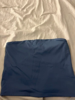 Blå tubtopp från New Yorker  - Säljer en enkel blå tubtopp från new Yorker  i storlek S. Toppen är ärmlös och har en slät design utan mönster eller detaljer. Materialet känns mjukt och stretchigt, perfekt för varma dagar. Färgen är klar blå och modellen är bandeau.