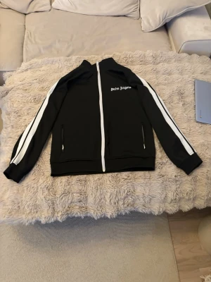 Palm Angels tracksuit . - Palm Angels set – storlek M (helt nytt) Säljer ett Palm Angels set (kofta + byxor) i storlek M. Helt nytt skick, aldrig använt. Säljs pga fel storlek, för stort på mig. Endast frakt. Ingen retur, fick dem i present, pris kan diskuteras.