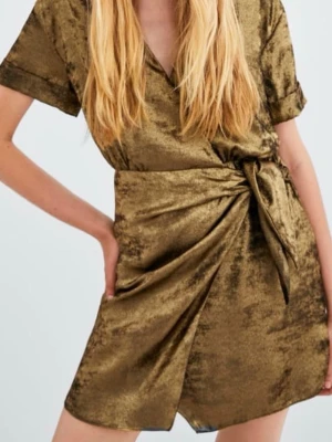  ZARA shiny metallic gold wrap dress - Snygg kort omlottklänning i guld från ZARA. Klänningen har v-ringad hals, korta ärmar och knyt i midjan som ger en cool draperad effekt. Materialet har en glansig, sammetsliknande finish.