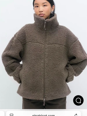 Brungrå teddyjacka med dragkedja - Mysig brun teddyjacka från Gina Tricot med hög krage och hel dragkedja framtill. Jackan har en loose passform och är tillverkad i mjukt fleece-material som håller dig varm under kyliga dagar..