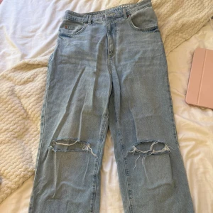 90s Straight ljusblå jeans med hål - Säljer ett par ljusblå jeans från Bikbok, med hög midja och raka ben i mycket bra skick. Storleken är 29 i midjan och 34 i längden. Passar därför perfekt för långa tjejer. 