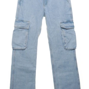 Ljusblå cargojeans med stora fickor - Säljer ett par ljusblå cargojeans med bred passform och stora fickor på sidorna. Byxorna har klassisk jeanslook och är perfekta för dig som gillar streetstyle och praktiska detaljer. Materialet är tåligt denim och färgen är riktigt fräsch.