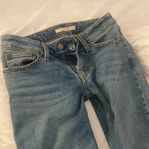 Levis 517 bootcut jeans ljusblå - Ljusblå Levis 517 jeans med klassisk bootcut-modell. Jeansen har fem fickor, dragkedja och knapp i midjan. Tillverkade i robust denim och har en snygg, tidlös tvätt. Perfekta för dig som gillar retrovibbar och vill ha ett par jeans med lite vidare ben. Väldigt lågmidjade. Oanvända 