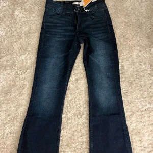 Mörklblå ootcut jeans midwaist  - Snygga mörkblå bootcut jeans från Gina Tricot i storlek 164. Modellen har midwaist och klassisk femficksdesign med broderade bakfickor. Jeansen är tillverkade i stretchigt denim för skön passform och har en stilren look som funkar till allt. Passar mig som bär XS, aldrig använda! Helt nya med prislapp .