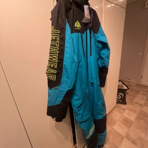 Jethwear Endurance blå overall - Säljer en blå och svart overall från Jethwear med stora loggor på ärmarna och bröstet. Jackan har flera dragkedjor framtill och på benen. Helt ny och oanvänd. Säljer på grund av fel storlek. 