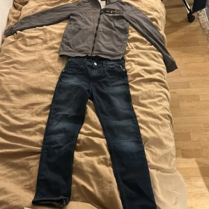 Mörkblå raka jeansbyxor - Snygga mörkblå jeansbyxor med klassisk femficksdesign och raka ben. Jeansen har normal passform och är tillverkade i ett slitstarkt denimtyg. Perfekta för dig som gillar en enkel och stilren look.  Stilren och bekväm Sail Racing-tröja i hög kvalitet. Tröjan har en klassisk passform och är tillverkad i mjukt material med Sail Racing-logga på bröstet. Perfekt till både vardags och fritid för dig som gillar en
