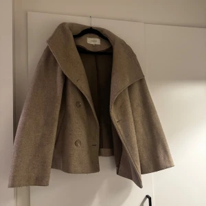 Beige kappa  - Snygg kappa från Bubbelroom, använd förra året men kommer inte till användning nu. Lite nopprig men går lätt att fixa. 