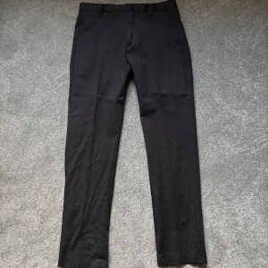 Svarta kostymbyxor med rak passform från Riley - Snygga svarta kostymbyxor, perfekt för lite finare tillfällen eller en lite mer uppklädd vardag! Nypris:999kr| Mitt pris: 499kr