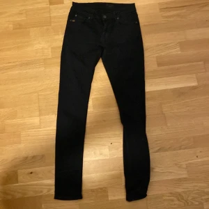 Svarta skinny/slim jeans Tiger of Sweden - Svarta jeans från Tiger of Sweden i modellen SLIM. Klassisk femficksdesign, smal passform och snyggt svart tyg med diskreta detaljer. Perfekta för dig som gillar stilrena och tajta jeans med modern känsla.