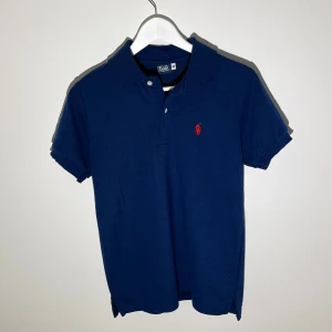Marinblå pikétröja från Ralph Lauren - Klassisk marinblå pikétröja från Ralph Lauren i storlek M