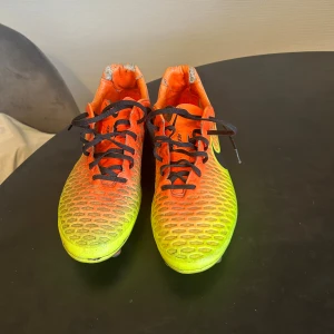 Nike magista elite - Säljer ett par Nike fotbollsskor i storlek 45 med grymt cool färgskiftning från orange till gul och svart swoosh. Skorna har svart snörning och mönstrad ovandel med ACC-teknologi för bästa bollkontroll i alla väder. Perfekta för dig som vill sticka ut på planen.