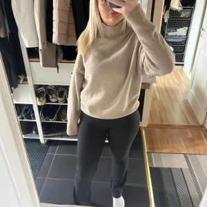 Beige polotröja från Gina Tricot - Säljer en beige polotröja från Gina Tricot i storlek S. Tröjan är stickad med ribbade muddar och har en hög krage som ger en chill vibe. Modellen är loose fit med långa ärmar och mjukt material som känns skönt mot huden.