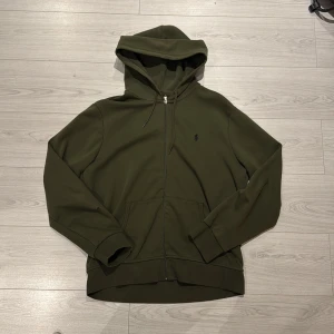 Ralph Lauren Hoodie Grön - Säljer min gröna Ralph Lauren hoodie i storlek Large. Hoodien är i bra skick. Ett litet hål i högra armen men absolut inget som syns vid användning. Hör av er vid fler frågor och bilder😊👍🏼