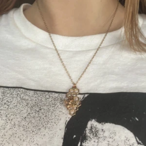 Guldigt halsband med bikupa och bi - Guld halsband med bikupa motiv. Köpt secondhand så har lite missfärgning på baksidan men ingenting som är särkilt märkbart.❤️