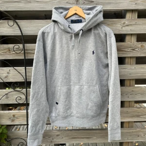 Ralph Lauren Grå Hoodie - Snygg grå Hoodie från Ralph Lauren. Storlek M, passar dock mer som en S skulle jag säga. Fint skick, har två mindre defekter som syns på de två sista bilderna, inget man tänker på. Hör gärna av er vid funderingar!🙌🏻