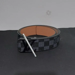 L bälte Svart Rutig - ● Helt ny, aldrig använt. Litet verktyg för att göra hål med är inkluderad 👍                                       ● Storlek: 110cm.                                                      ● Fraktar inom 24h, så att du får paketet så fort som möjligt! 📦                                                                          Vid frågor eller intresse, dm. 😁
