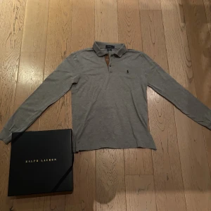 Långärmad pikétröja Ralph Lauren - Skitsnygg långärmad pikétröja från Ralph lauren. Använts sparsamt och är väl omhändertagen. Boxen ingår. Slim-fit modell så sitter snyggt och blir inte baggy