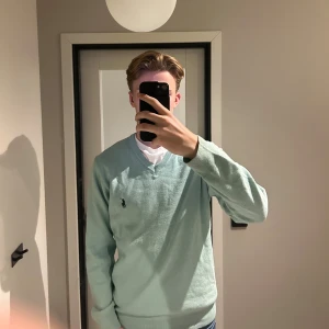 Ljusgrön v-ringad tröja Polo Ralph Lauren - Snygg ljusgrön v-ringad tröja från Polo Ralph Lauren med klassisk broderad logga på bröstet. Tröjan har lång ärmad. Perfekt för dig som gillar stilrena och tidlösa plagg. Den är prefekt för att ha en skjorta under. Jag säljer den då den inte är min typ av tröja och inte används 