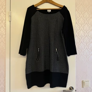 Svart och vit mönstrad klänning - Snygg svart och vit kortklänning från Cassels med trekvartsärm och coolt grafiskt mönster. Köpt flera år sedan så säljs inte längre o butik. Endast använd ett fåtal gånger. 