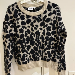  Ny Leopardmönstrad stickad tröja från VILA - Snygg stickad tröja från VILA med beige botten och svart leopardmönster. Tröjan har rund halsringning, ribbade muddar och lång ärm. Perfekt för dig som vill sticka ut lite extra i höst och vinter. Supermjuk och skön att ha på sig. Aldrig använd , det är som en S i storlek 