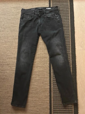Replay svarta jeans, storlek 32/32 - Svarta jeans från Replay i modellen Anbass, med smal passform och klassisk femficksdesign. Jeansen har en snygg tvättad look och är tillverkade i stretchigt bomullsmaterial för extra komfort. Perfekt för dig som gillar stilrena och moderna jeans. Om du har någon fråga är det bara att höra av dig. Pris går att diskutera 