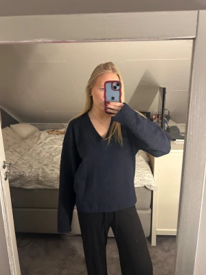 Mörkblå stickad tröja m v-ringning - En mörkblå stickad tröja med v-ringning från Nelly i storlek xs. Säljer då jag inte använder den längre!