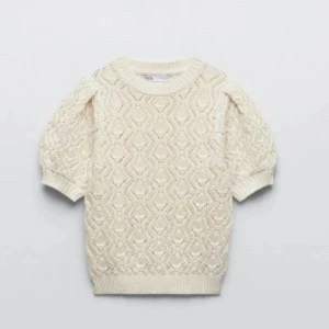 Creme Vit stickad topp med kort ärm Zara - Superfin creme vit stickad topp från Zara med korta puffärmar och snyggt hålmönster. 