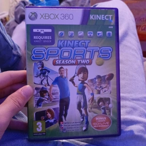 Kinect Sports Season Two (Xbox 360) - Kinect Sports Season Two till Xbox 360, komplett med fodral och skiva i fint skick. Kräver Kinect-sensor och erbjuder flera sportspel som tennis, golf och amerikansk fotboll. Perfekt för familjeunderhållning och rörelsebaserat spelande.