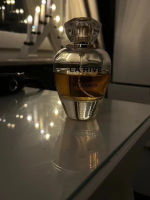 La Rive In Flames parfym - Upptäck La Rive In Flames – en elegant parfym som ger en lyxig känsla till din stil. Perfekt för dig som vill sticka ut och addera en touch av glamour till vardagen. Snygg flaska som passar perfekt på sminkbordet.