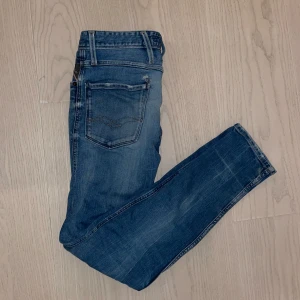 Blå Replay Jeans - slimfit - Säljer dessa sköna Replay jeans. Perfekt för att matcha en snygga tröja med! Jeansen är i 27:32, alltså slimfit. OBS! Jeansen har ett litet hål vid fickan (se bild), därav det låga priset! Bortsett från det är de i mycket bra skick! Jag skulle säga att jeansen passar folk mellan 165-175 beroende på vilken passform man är ute efter! Hör av er vid minsta fundering eller fråga! Bilder finns för den som är i nöd! Pris ej hugget i sten!