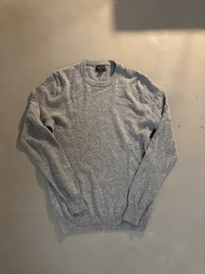 Grå kashmirtröja från J.Crew - Superskön grå tröja i 100% kashmir från J.Crew. Rund hals och långärmad med ribbade muddar vid ärmslut och nederkant. Perfekt för dig som gillar mjuka och lyxiga material. Enkel och stilren design som funkar till allt.