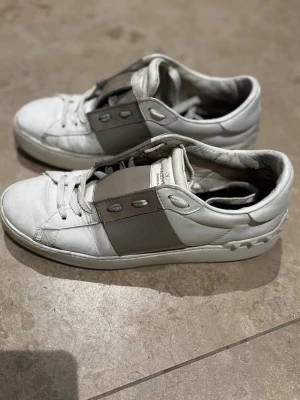 Valentino Garavani Open sneakers vit/beige - Säöjer ett par beiga valentino skor i storleken 39 på ena skon är dom slitna i hälen å sen har dom fler defekter som man ser på bilderna men annars fina💕